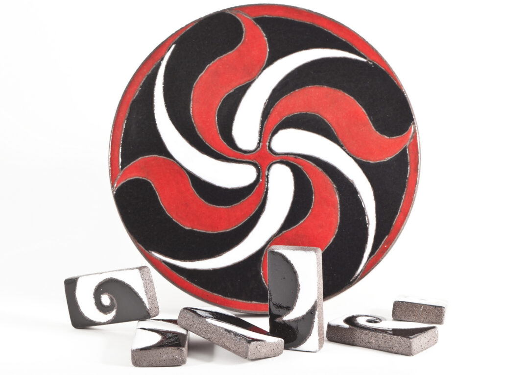 Dessous de plat en pierre de lave émaillée rouge, noir et blanc et repose couverts en pierre de lave émaillée (photo par Pierre-Alain Heydel).