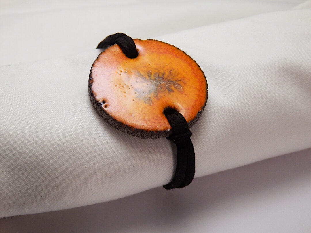 Bracelet souple en pierre de lave émaillée orange de la collection cristal (photo par L'île o Pierres).