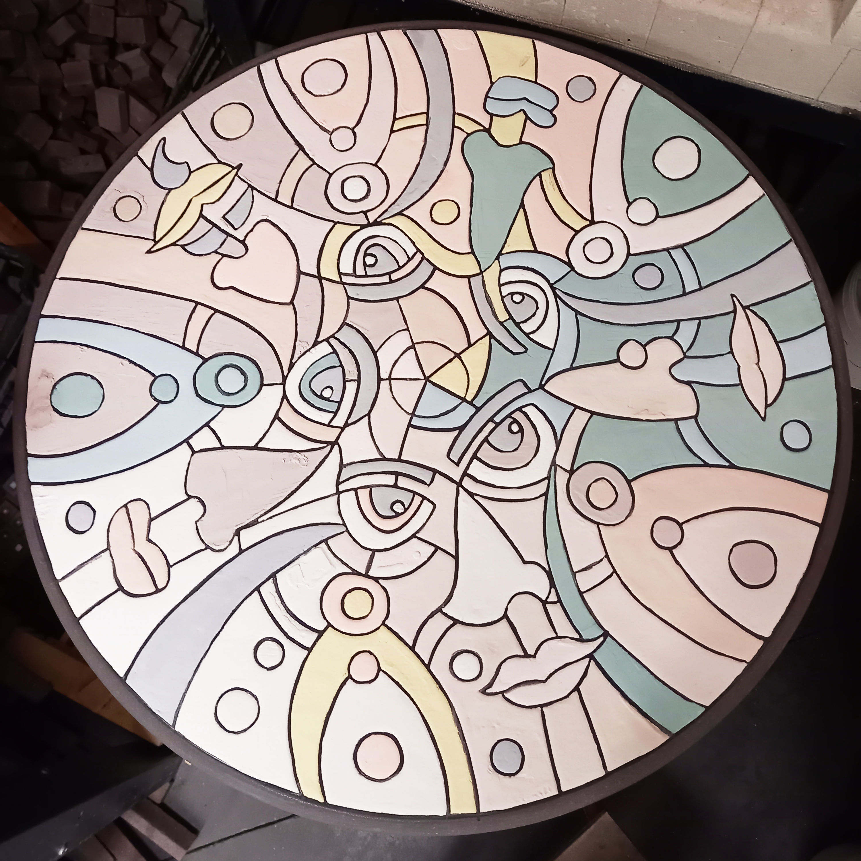 Table bistrot en pierre de lave émaillée avec motifs de visages intriqués avant cuisson (photo par L'île o Pierres).
